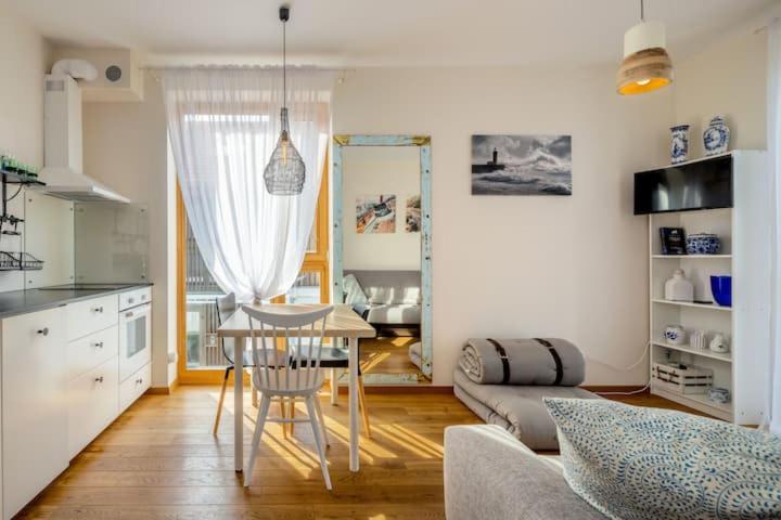 a kitchen and living room with a table and a couch at Pino Home in Neringa