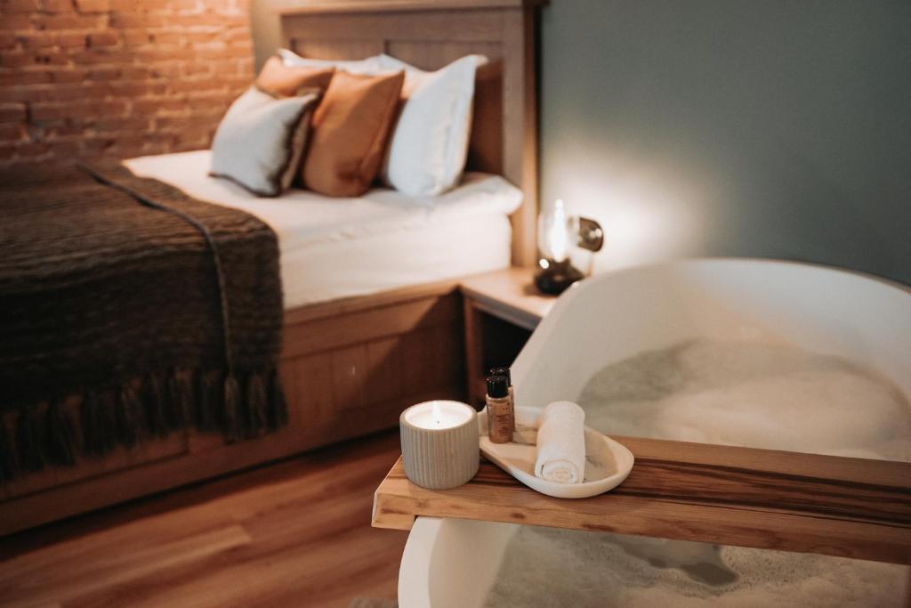 a bathroom with a bath tub and a bed at Apartment No 14 in Līgatne