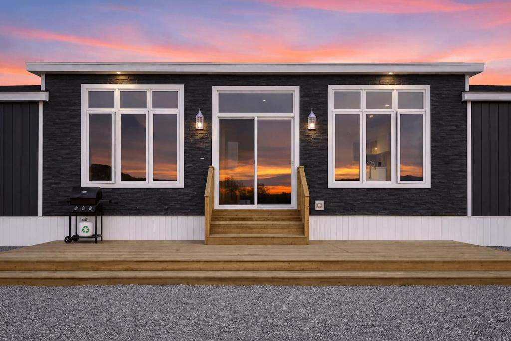 a rendering of a house with a sunset at Oceanfront Escape on the Cabot Trail by Cabotopia in Chéticamp
