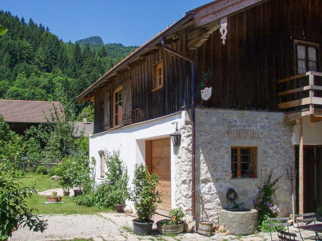 a stone house with a wooden roof and a door at Mountain House With Sauna In Sachrang in Sachrang