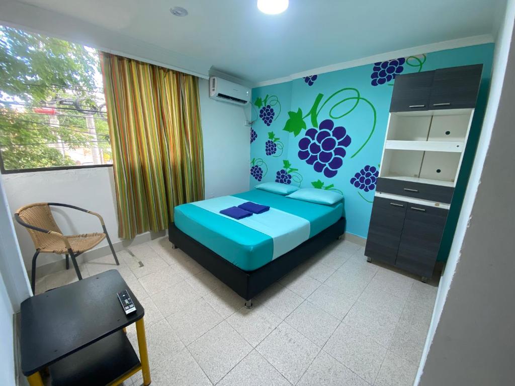 a bedroom with a blue bed and a chair at Tamarindo in Santa Marta