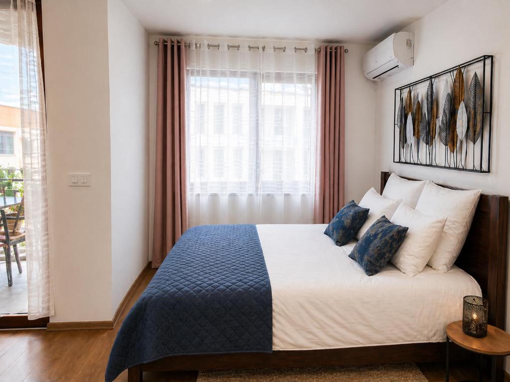 a bedroom with a large bed with blue pillows at Apartman Modiano in Vrnjačka Banja