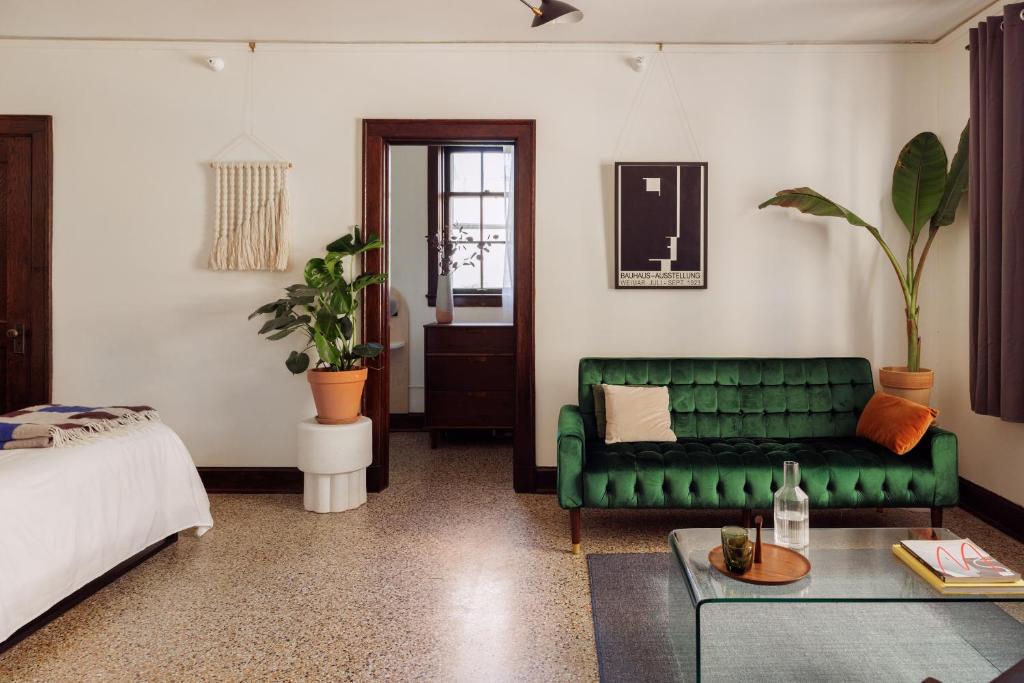 a living room with a green couch and a bed at The Wilson in Madison