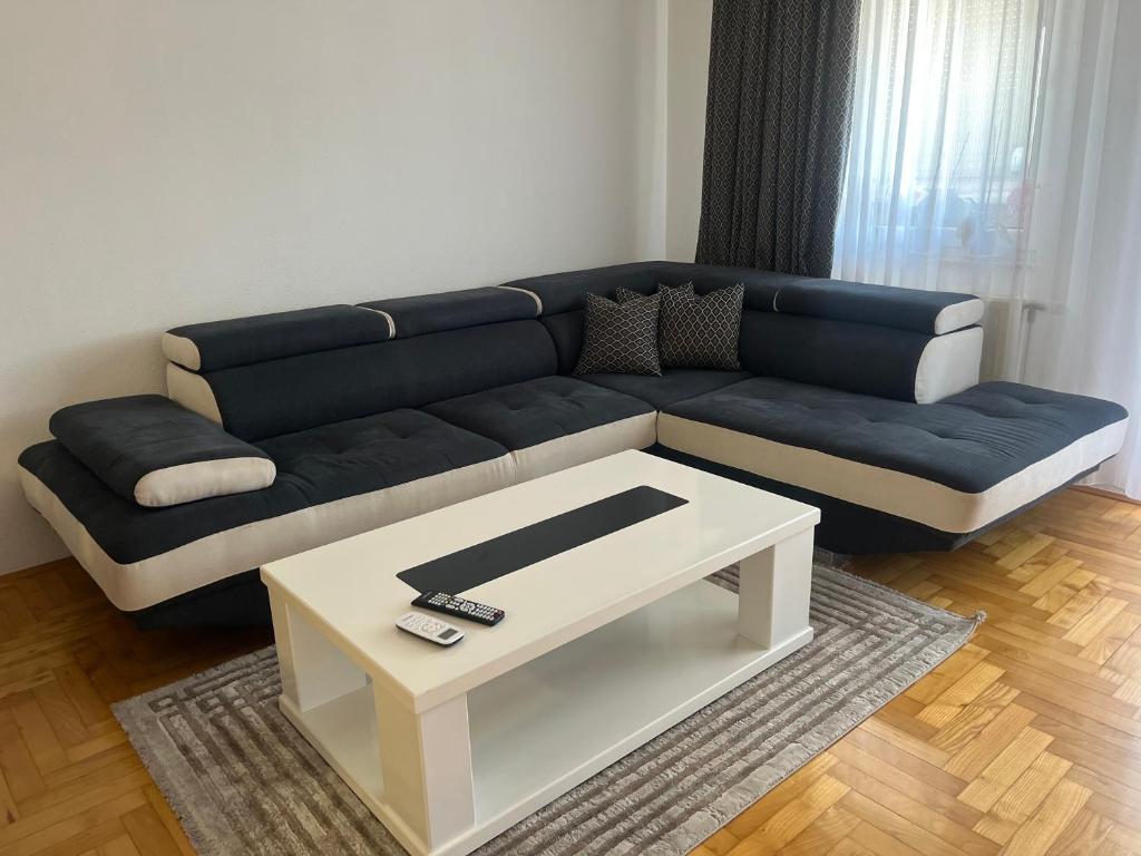 a living room with a blue couch and a coffee table at Stan na dan Šamac in Bosanski Šamac