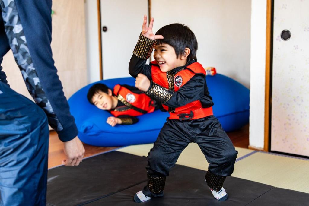 a young boy dancing in a room with another child at Ninja Village - Miyajima in Hatsukaichi