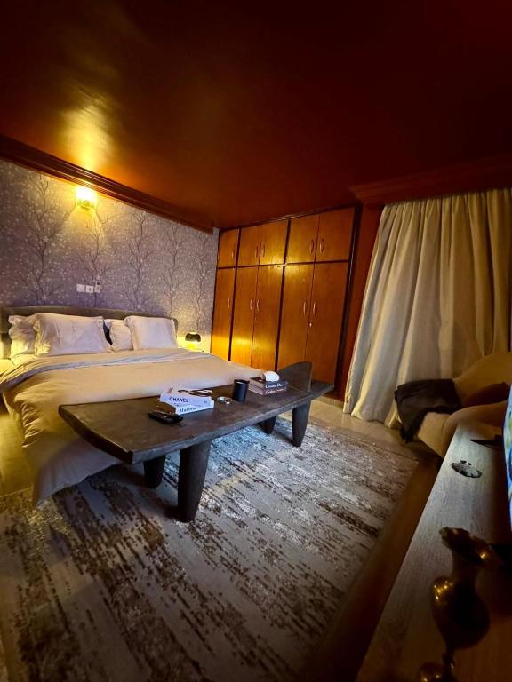 a bedroom with a large bed and a table at Appart G2 in Abidjan