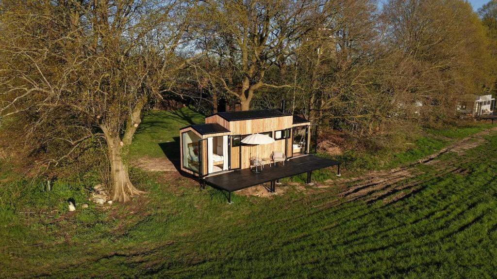 a tiny house sitting on top of a lush green field at NOAH Cabin No2 - An wunderschöner Windmühle in Beverstedt