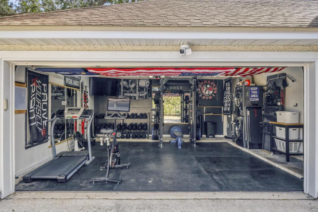 a garage with a garage door open to a gym at Relaxed Poolside Gym Escape in Green Cove Springs