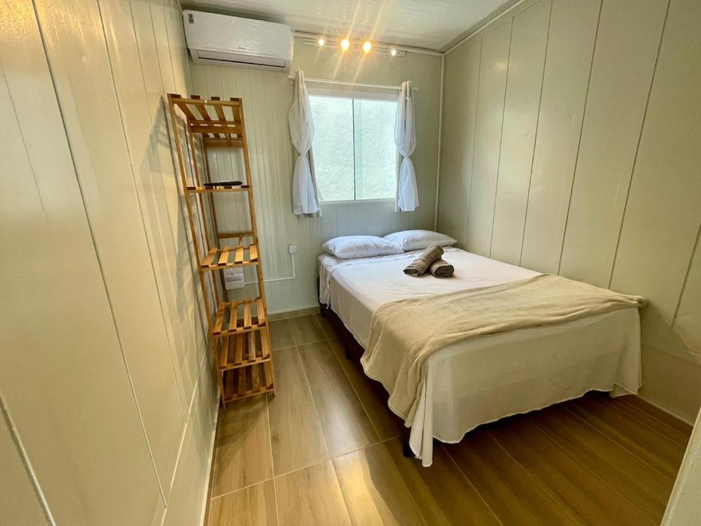 a small room with a bed and a ladder at 12 · Studio 22 Itajaí microcasa in Itajaí
