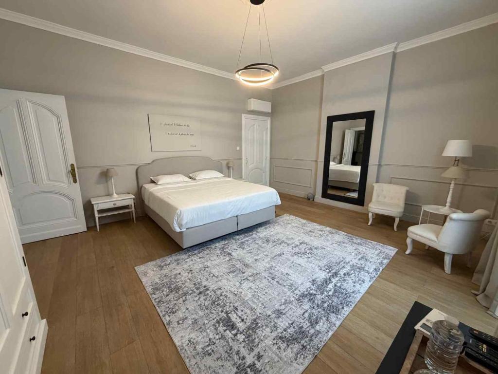 a white bedroom with a bed and a rug at Villa Damseaux in Spa