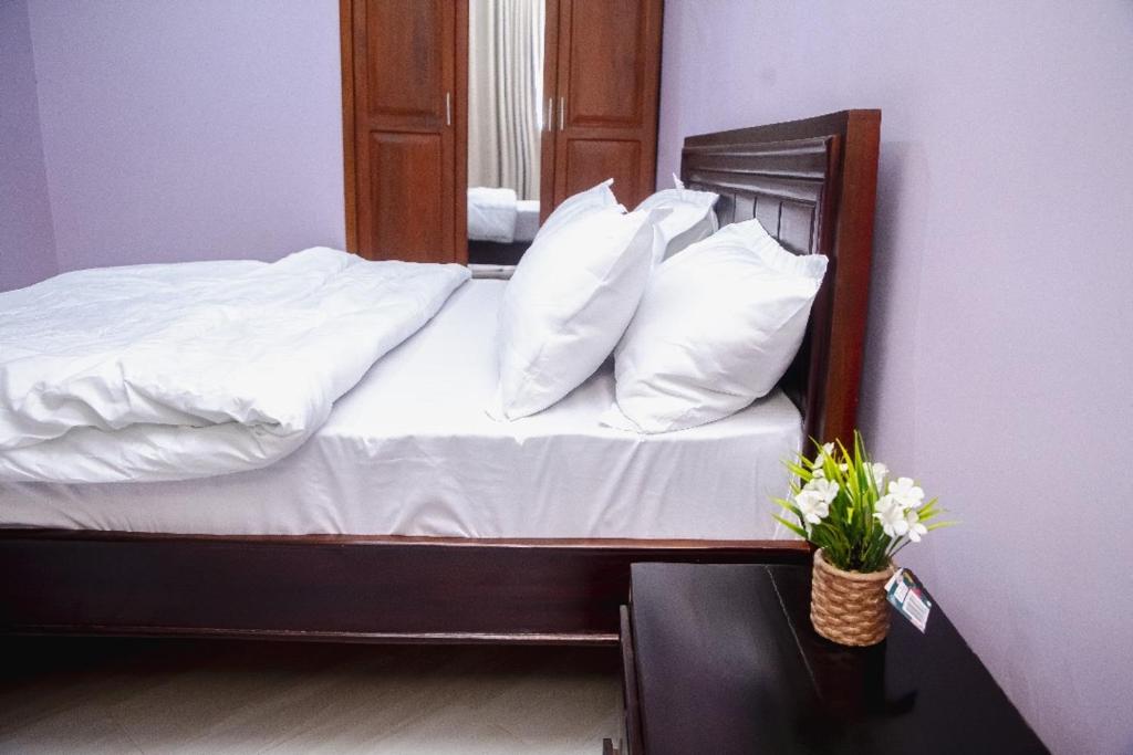 a bed with white sheets and pillows in a room at Jeswel Lux villa in Dodoma