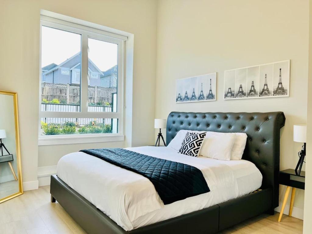 a bedroom with a large bed and a window at Family Friendly Ground Level Condo in Surrey