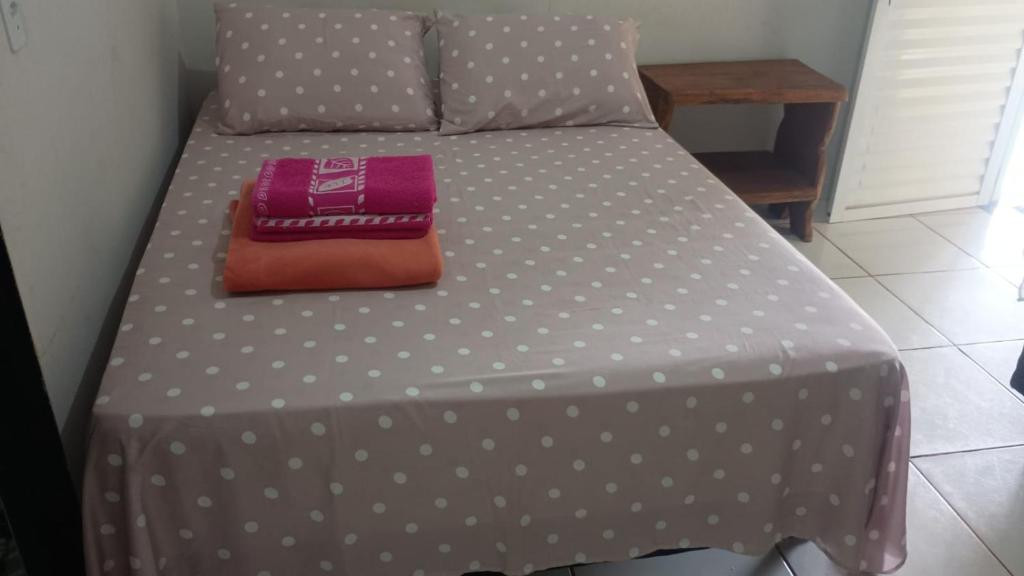 a bed with polka dot sheets and a purse on it at Pousada são Martins in Estivado