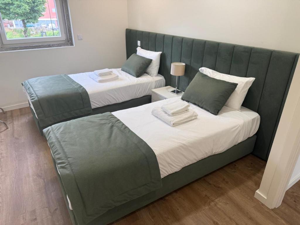 two beds sitting next to each other in a room at O Vilarealense Heritage Apartment in Vila Real