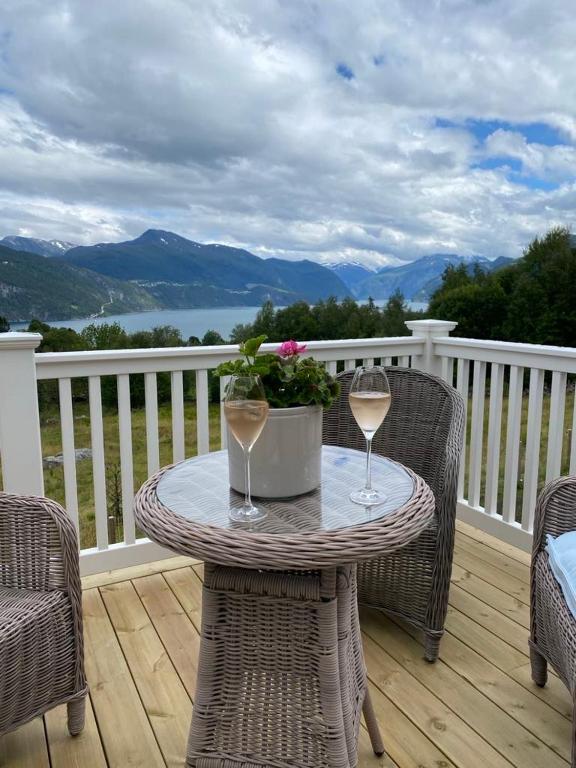 a table with two glasses of wine on a balcony at Villa Skoglund in Stranda