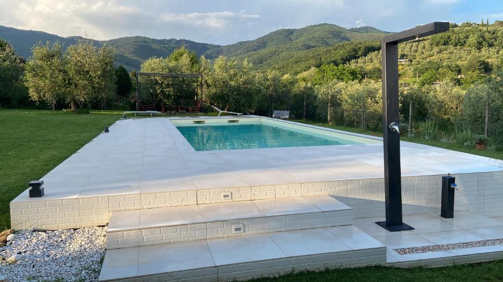 a swimming pool in a yard with mountains in the background at Il Piccolo Oliveto in Arezzo