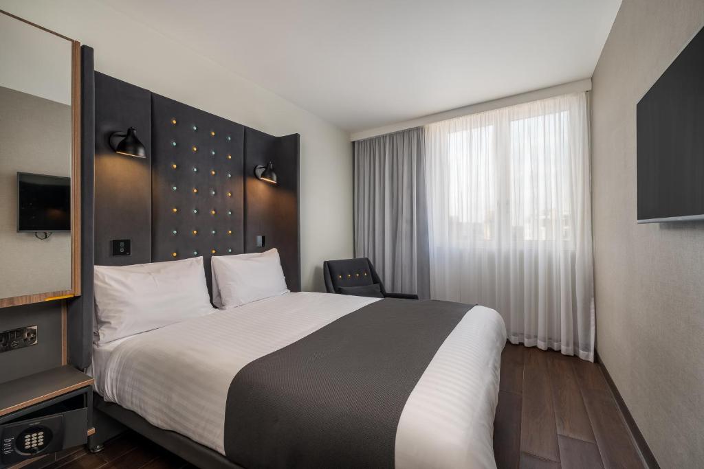 a hotel room with a large bed and a window at Point A Hotel Edinburgh Haymarket in Edinburgh