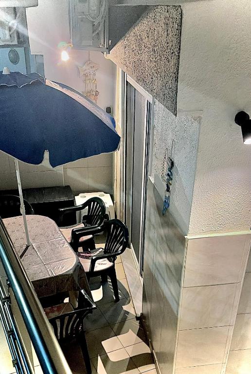 a room with two chairs and a table and an umbrella at Billis Cologne Apartment in Flogita