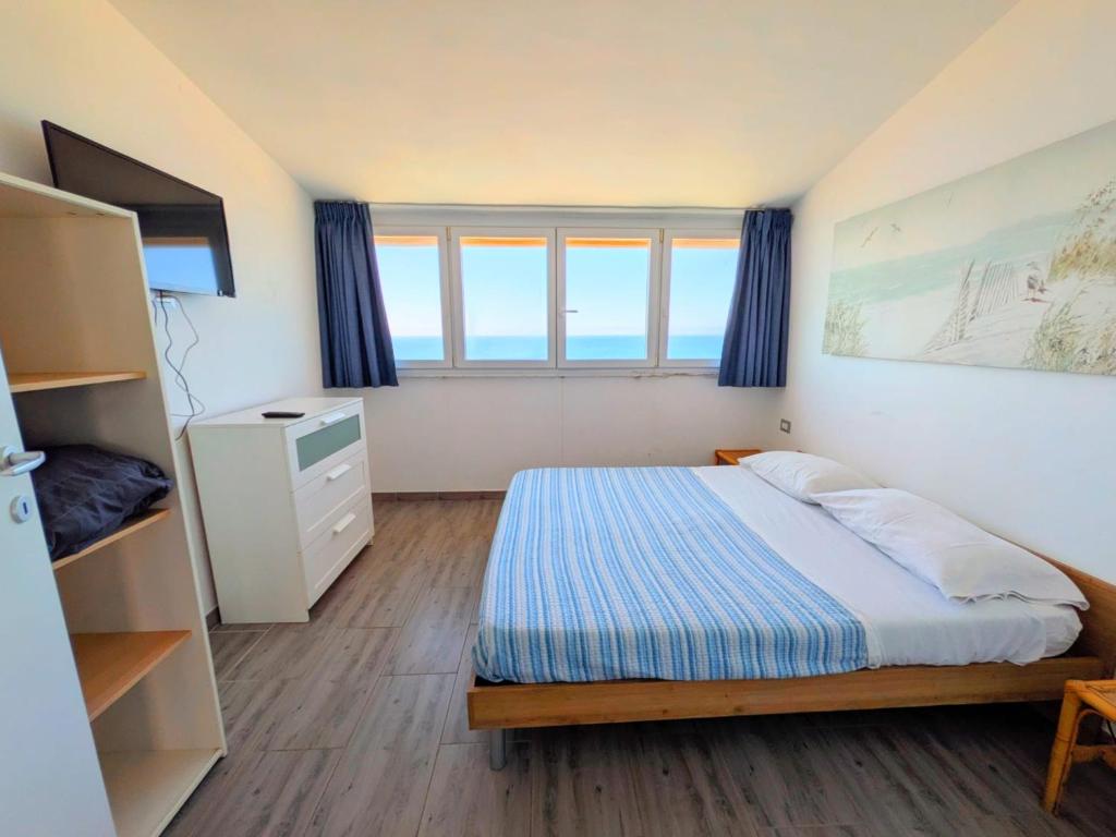 a bedroom with a bed and a large window at ESPRESSO VISTA MARE, Ostia Antica in Lido di Ostia