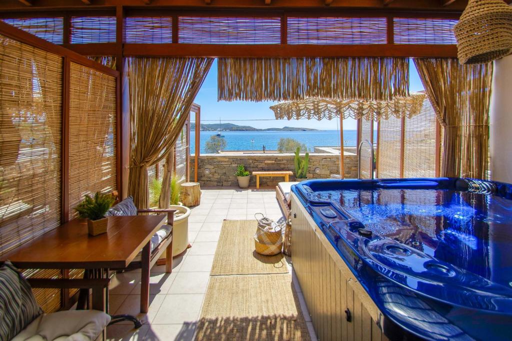 a large blue tub in a room with a view of the ocean at Syros Wellness Luxury Suites in Finikas