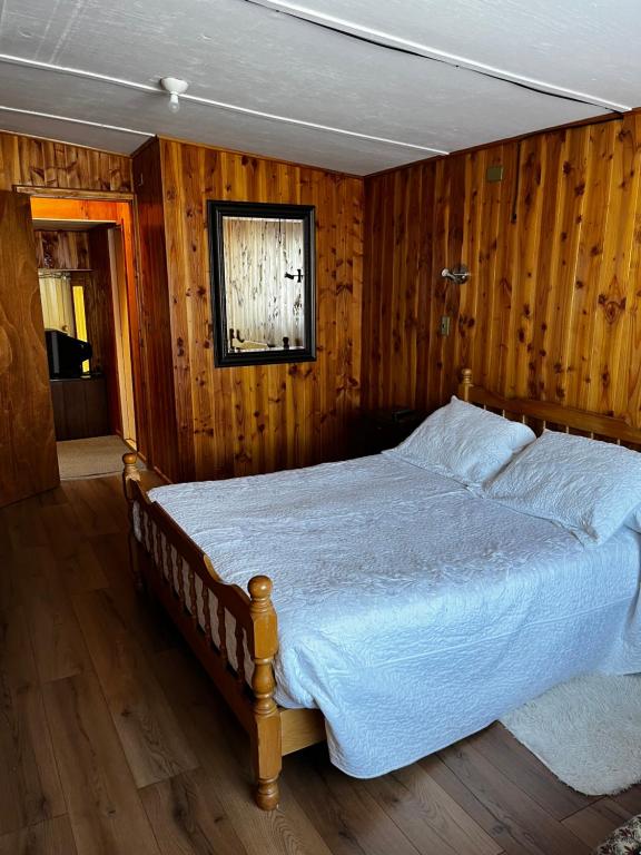 a bedroom with a large bed with wooden walls at Hospedaje Lala in Villarrica