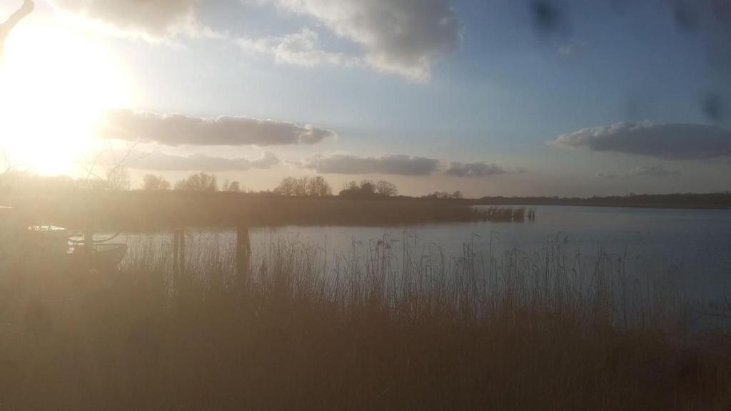 a sunset over a body of water with the sun shining at Ferienwohnung an der Ostsee in Dassow