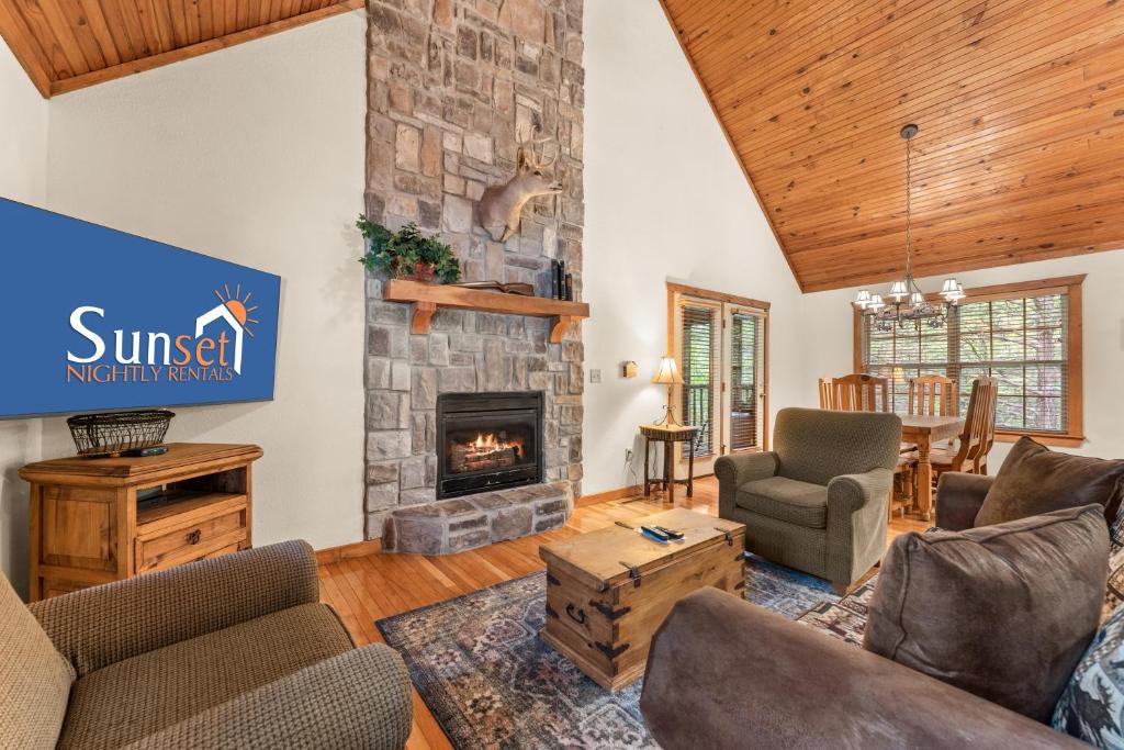 a living room with a fireplace and a sign that reads sunset mutual agency at SBL14 -Mayberry Lodge in Branson West