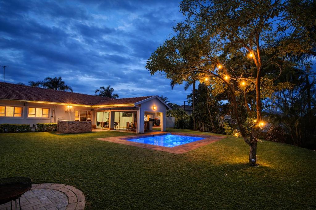 a house with a swimming pool in a yard at night at Umhlanga La Lucia Oasis, Family Friendly Accommodation in Durban