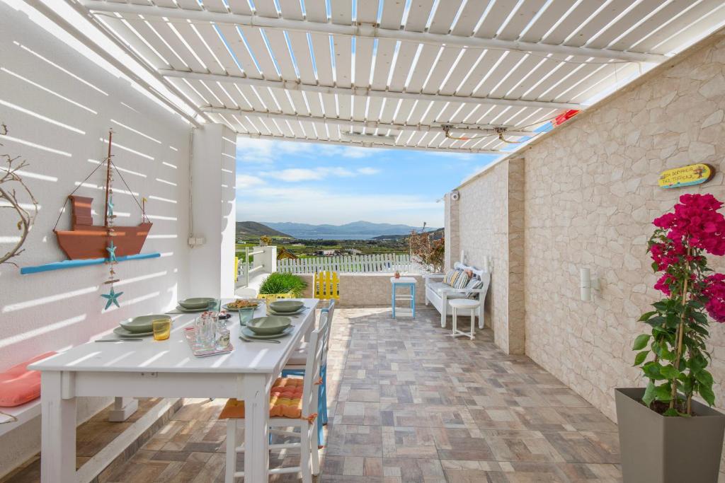 a patio with a white table and chairs at Antigone's Blue Vista in Kampos Paros
