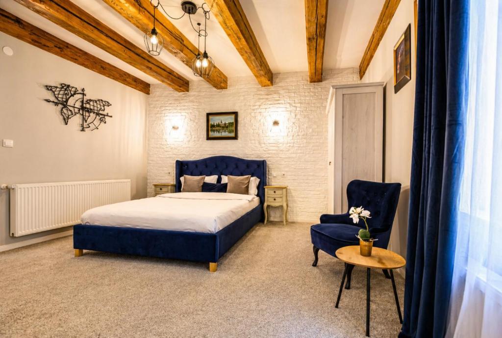 a bedroom with a bed and a table and a chair at Dallure House Boutique Brasov in Braşov