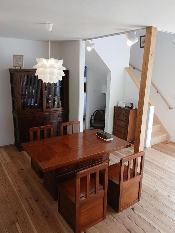 a dining room with a wooden table and chairs at Guesthouse Oomiyabase25 大宮基地 別荘新館 in Chiba