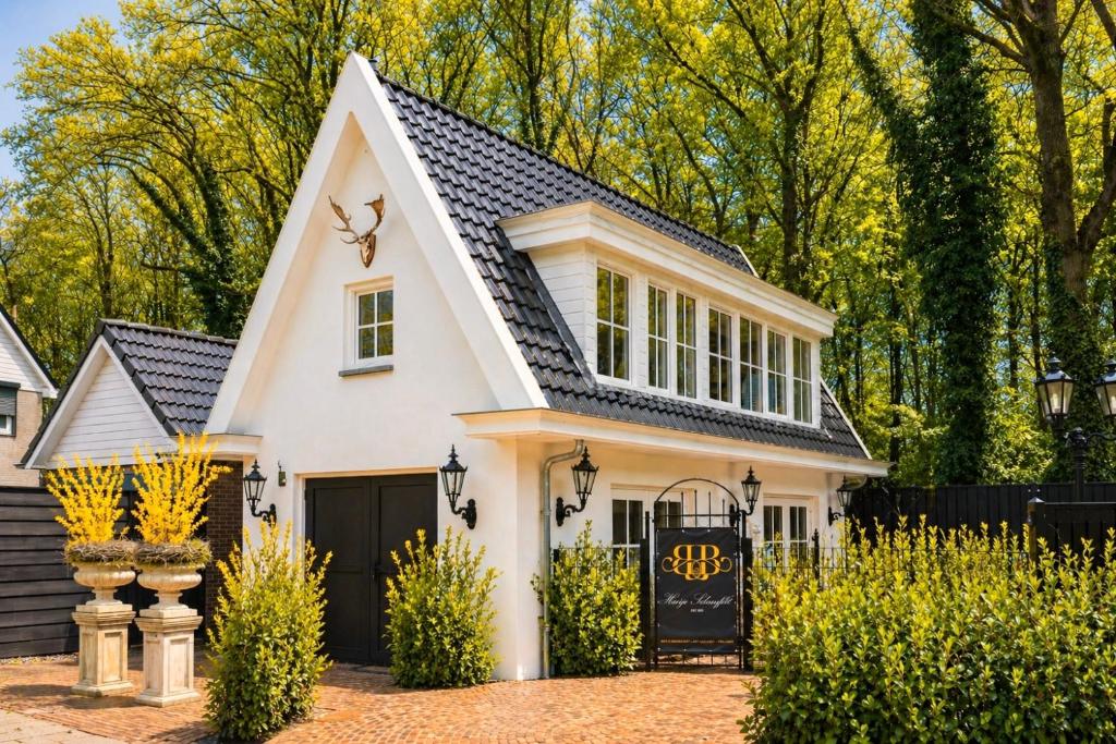 a white house with a black roof at B&B Huisje Schaufeli in Apeldoorn