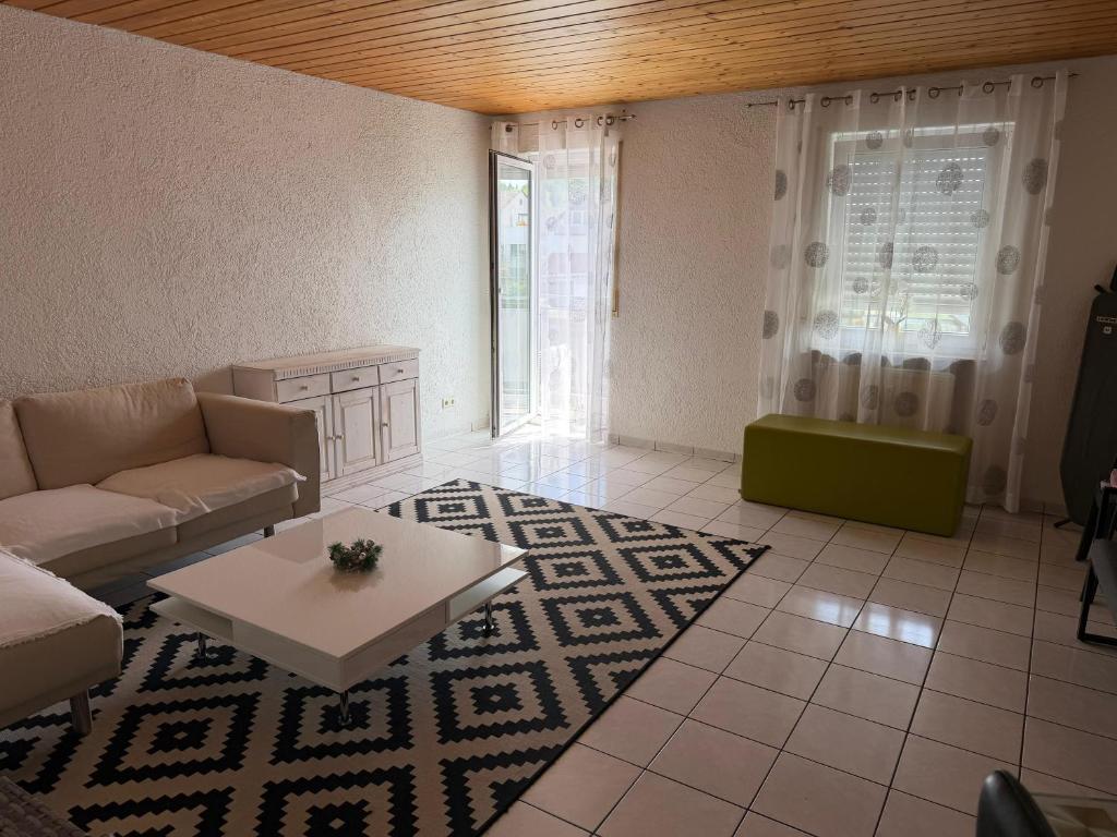 a living room with a couch and a table at Eltons Fewo beim EuropaPark 4- Zimmer Apartment in Herbolzheim