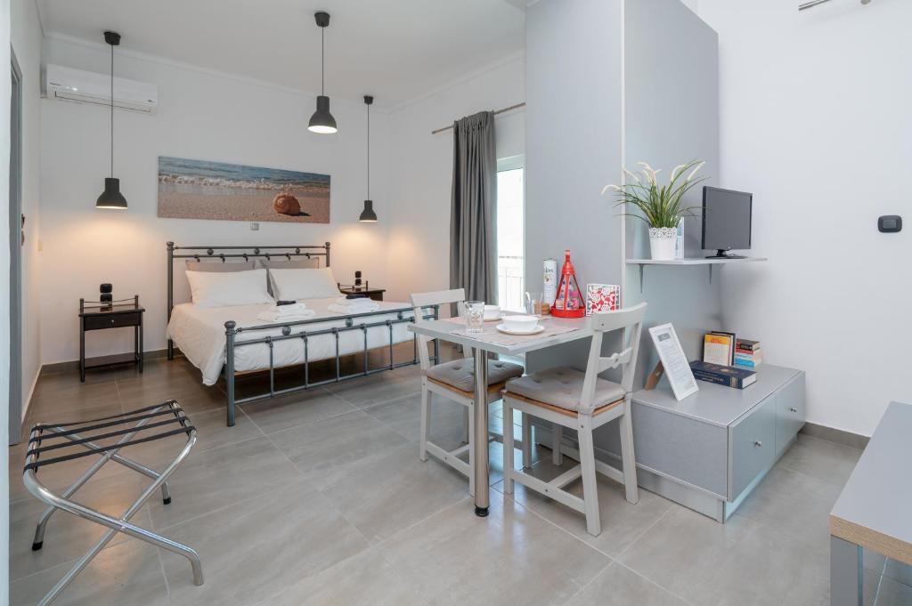 a bedroom with a bed and a table and a desk at Milva Apartments in Kos