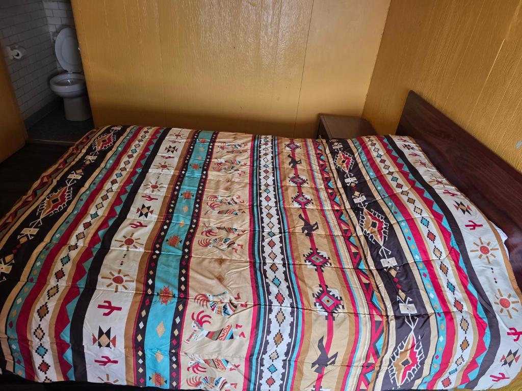 a bed with a colorful quilt on top of it at Lee motel in Nashville