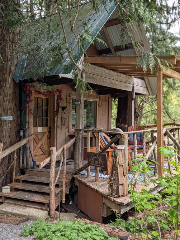 a wooden house with a porch and a door at Magnolia Cottage Bigfoot Hideaway in Hope