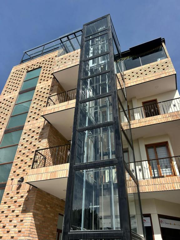 a glass elevator in front of a building at Hotel San Benito Cuenca in Cuenca