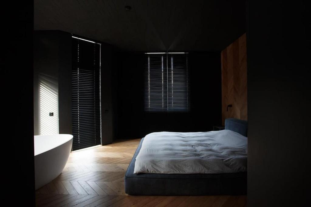 a bedroom with a bed and a tub in a room at CrownPlaza Boutique & Central in Chişinău