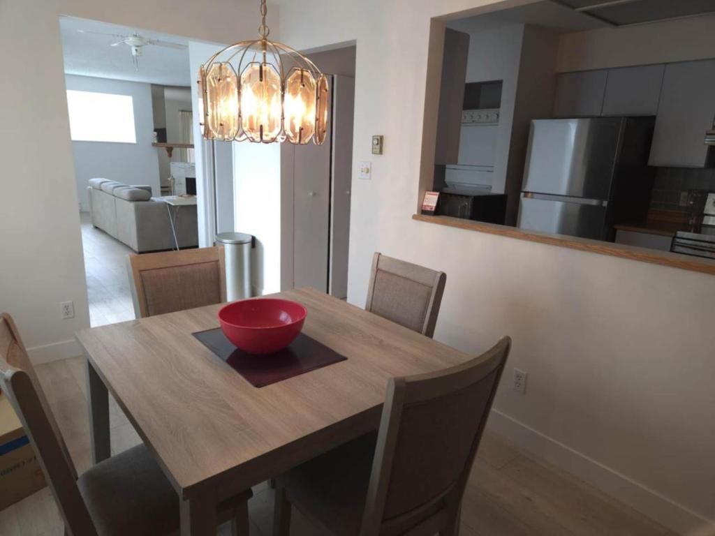 a dining room table with a red bowl on top of it at unique Two -Bedroom Central Townhouse in Vancouver
