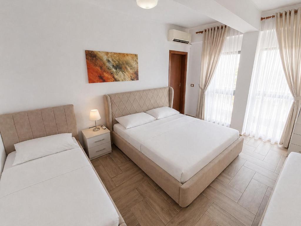 a bedroom with two beds and a window at Hotel Villa Megi in Golem