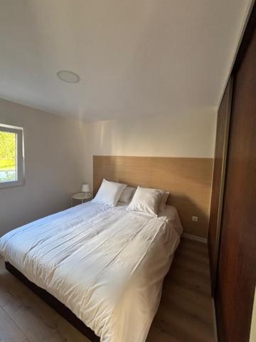 a bedroom with a large bed with white sheets at Casa papillon in Outeiro