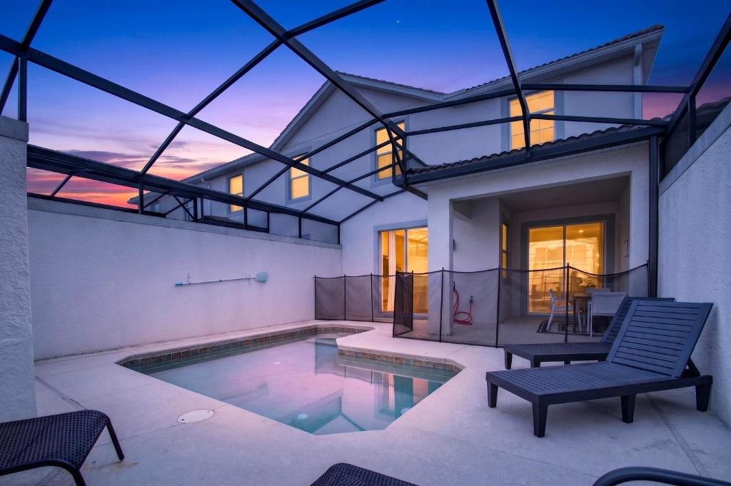 a house with a swimming pool and a patio at 1556 PD - Poolside Bliss: Enchanted 4BR Townhome in Davenport