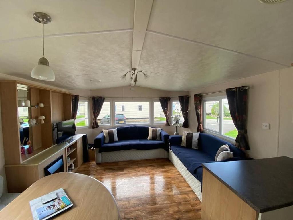 a living room with a blue couch and a table at 2 bedroom, robin Hood rhyl in Rhyl