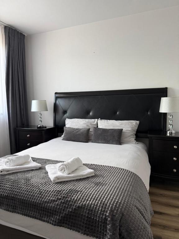 a bedroom with a large bed with two towels on it at Laura Apartament in Târgu-Mureş
