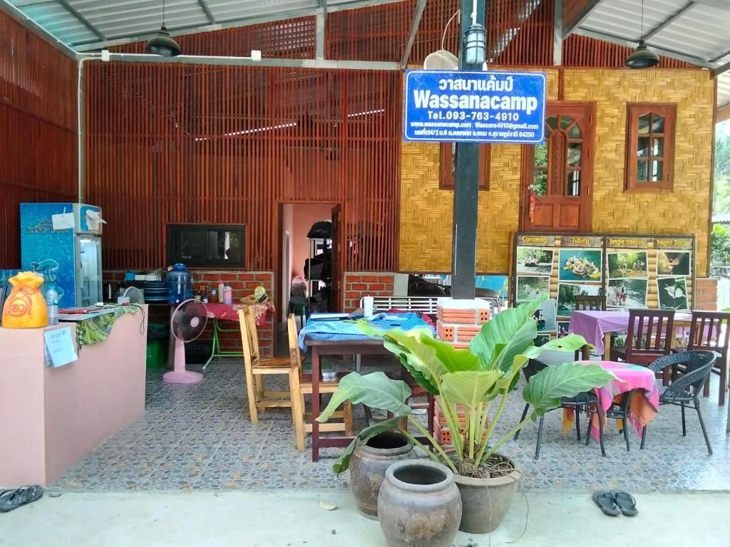 a restaurant with tables and chairs and a sign at Khai jungle wassanacamp in Ban Thung Lang Tham