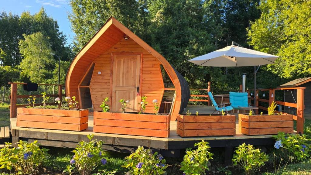 a wooden cabin with a table and an umbrella at Tiny House in Trape