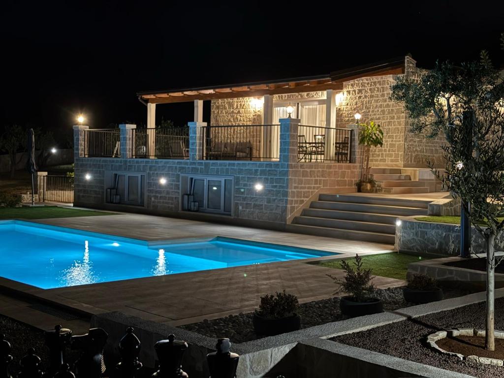 a swimming pool in front of a house at night at Villa Maginja in Sutivan