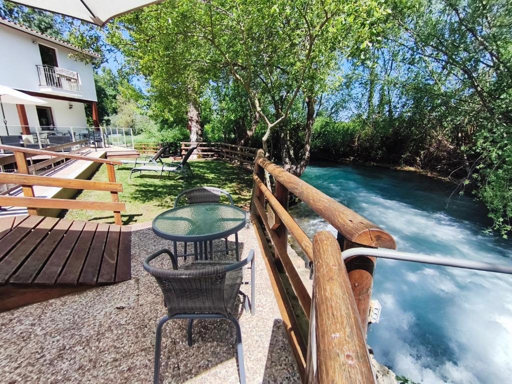ein Tisch und Stühle auf einer Brücke über einen Fluss in der Unterkunft Moinho Real in Redinha