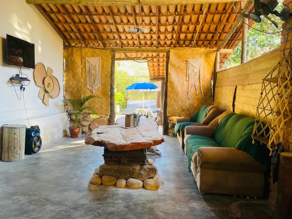 a living room with a table and a couch at Sítio com suítes e áreas de Lazer in Palmeiras