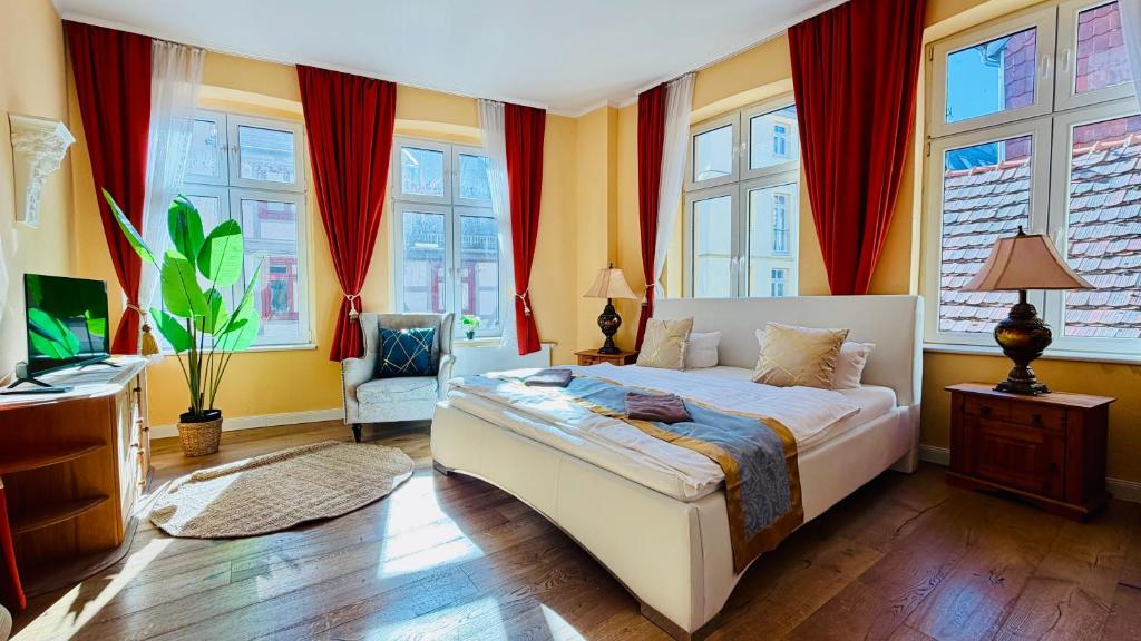 a bedroom with a bed with red curtains at FewoZauber "Pension am Dom", Historische Apartments, Superzentral, 7min zum Schloss in Schwerin